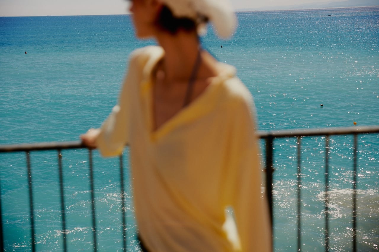 Guest on a hotel balcony overlooking the turquoise sea