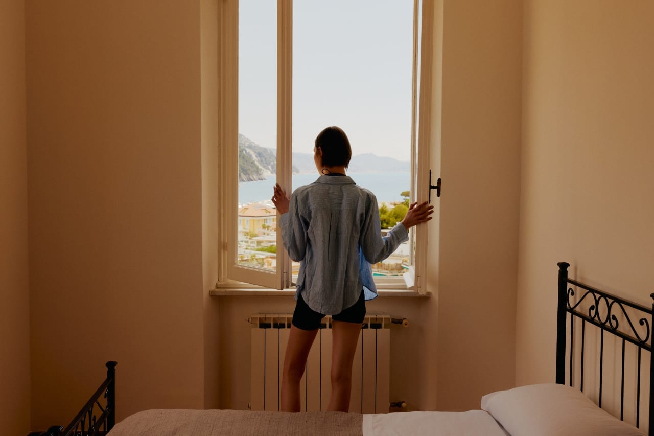 Guest opening their room window toward the sea